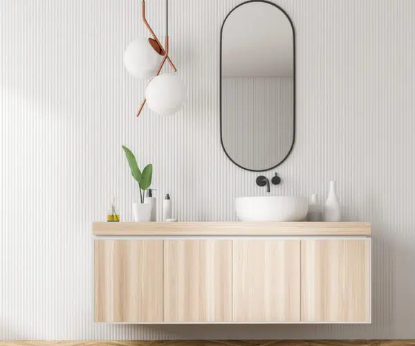 Speil på veggen på et bad med vaskeservant foran
